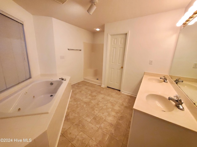 bathroom with plus walk in shower, tile patterned flooring, and vanity