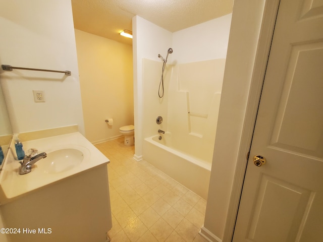 full bathroom featuring vanity, a textured ceiling, bathing tub / shower combination, and toilet