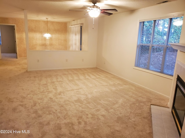 unfurnished room featuring ceiling fan, light colored carpet, and a textured ceiling