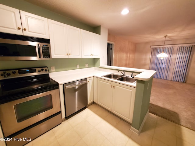 kitchen featuring kitchen peninsula, light carpet, stainless steel appliances, pendant lighting, and white cabinetry