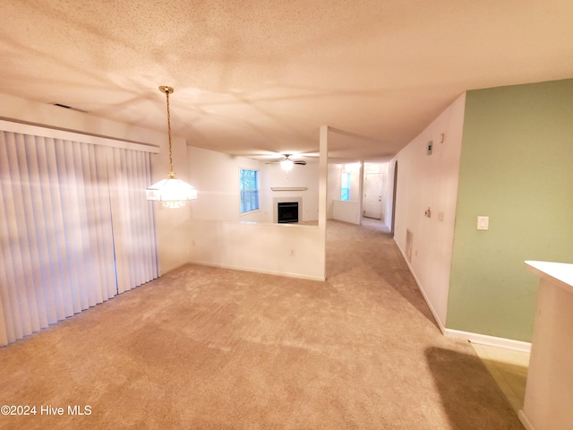 interior space with ceiling fan, light colored carpet, and a textured ceiling