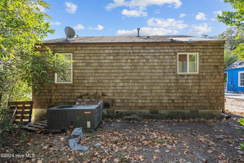 view of side of home with central AC