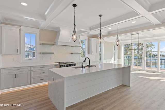 kitchen with a center island with sink, white cabinets, and sink