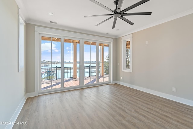 spare room with ceiling fan, light hardwood / wood-style floors, a water view, and ornamental molding