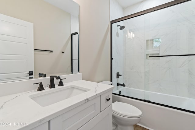 full bathroom featuring shower / bath combination with glass door, vanity, and toilet