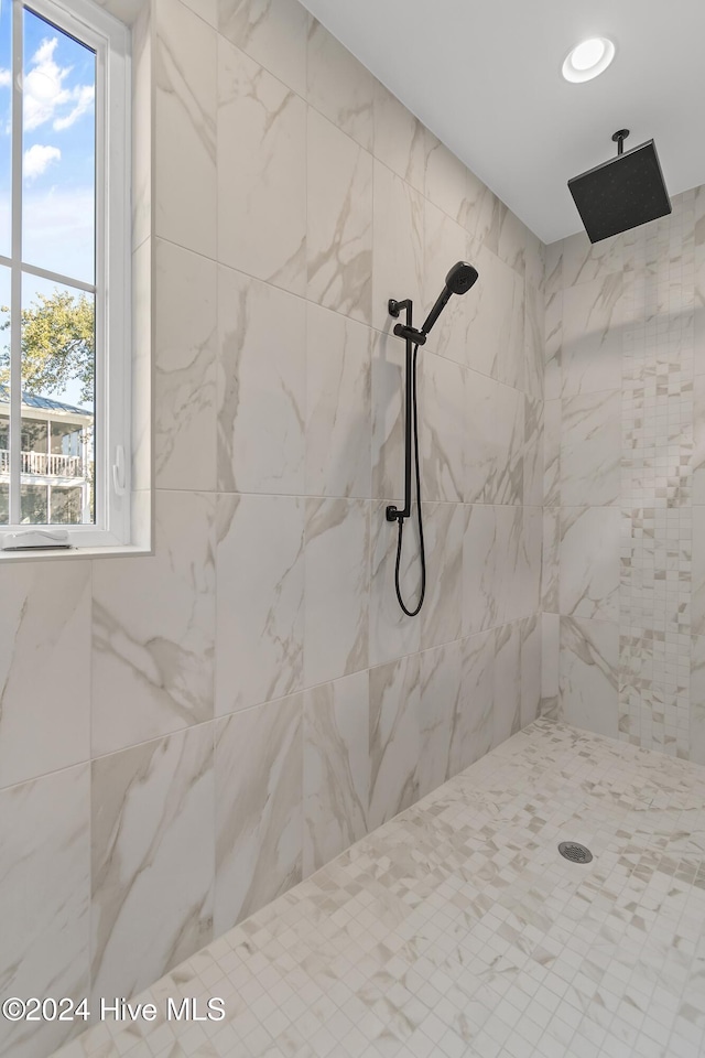 bathroom with plenty of natural light and tiled shower