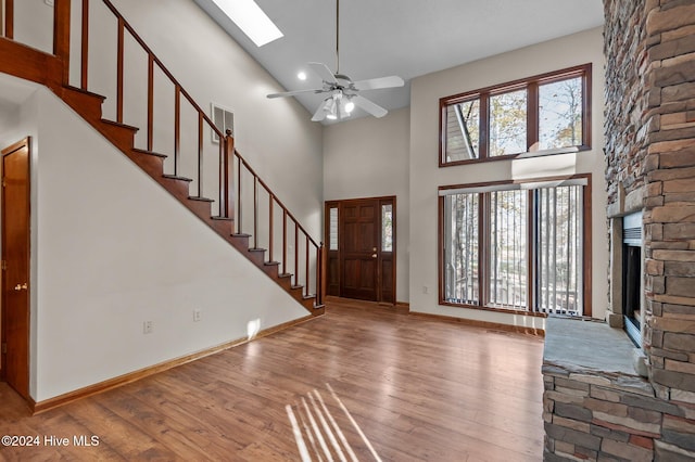 foyer featuring ceiling fan, a high ceiling, and light wood-type flooring