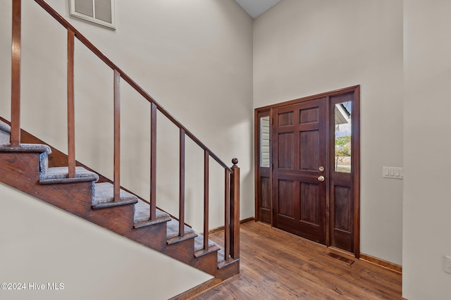 foyer featuring hardwood / wood-style floors and a high ceiling