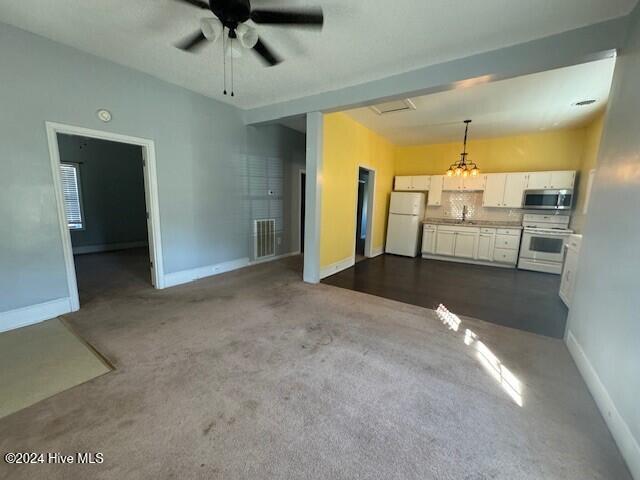 living room featuring ceiling fan with notable chandelier