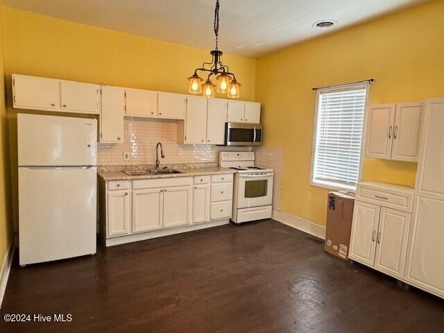 kitchen with sink, white cabinets, pendant lighting, and white appliances