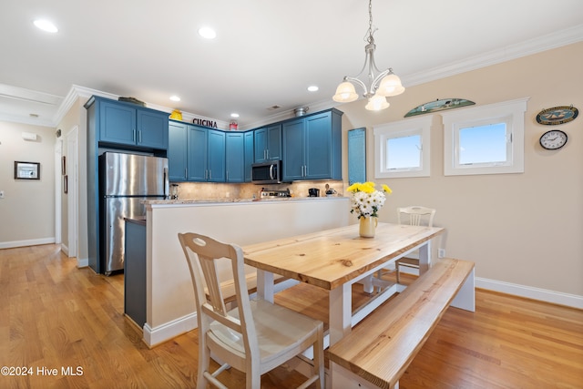 dining room featuring an inviting chandelier, light hardwood / wood-style flooring, and crown molding