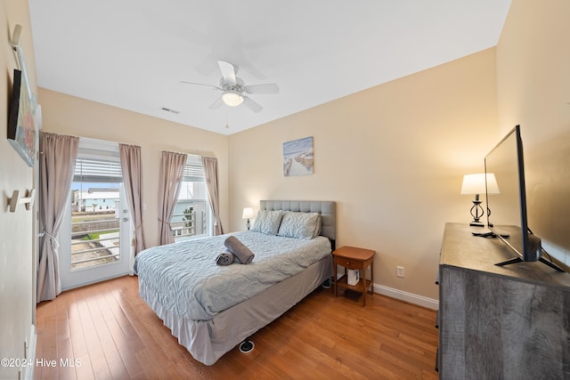 bedroom featuring access to exterior, wood-type flooring, and ceiling fan