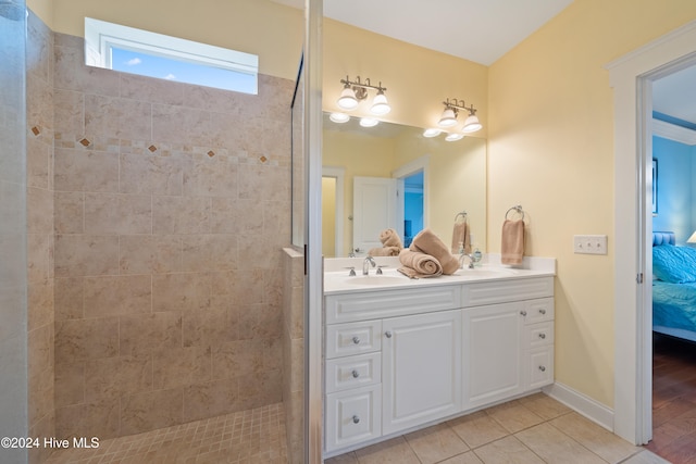 bathroom with hardwood / wood-style floors, vanity, and tiled shower