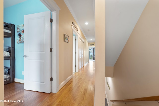 hall with light hardwood / wood-style flooring and crown molding