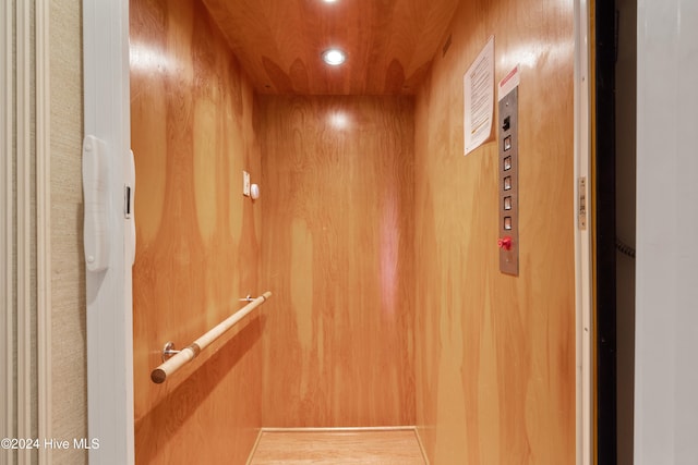 room details featuring wood walls and elevator