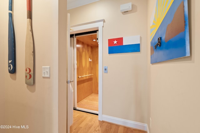 hall with hardwood / wood-style flooring and ornamental molding