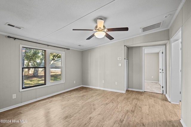 interior space with a textured ceiling, vaulted ceiling, ceiling fan, crown molding, and light hardwood / wood-style flooring