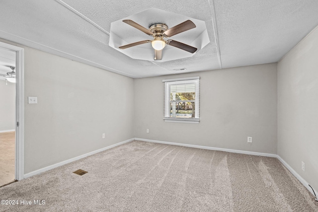 carpeted spare room with a textured ceiling and ceiling fan