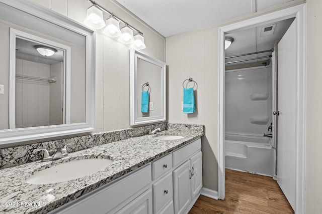 bathroom with shower / bathing tub combination, hardwood / wood-style floors, vanity, and a textured ceiling