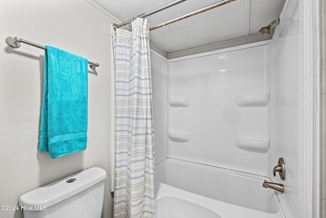 bathroom featuring shower / bathtub combination with curtain, a textured ceiling, and toilet