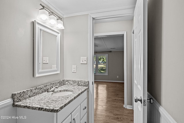 bathroom with vanity, wood-type flooring, and ornamental molding