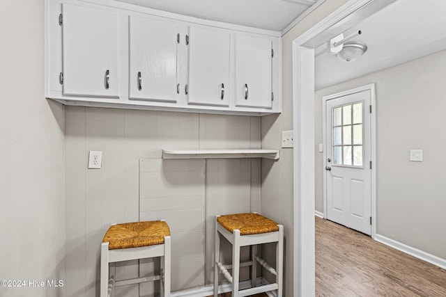 interior space with wooden walls, light hardwood / wood-style floors, and a textured ceiling