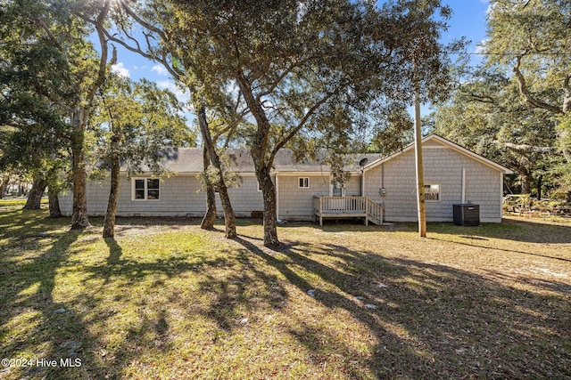 exterior space featuring a lawn, a wooden deck, and central AC unit