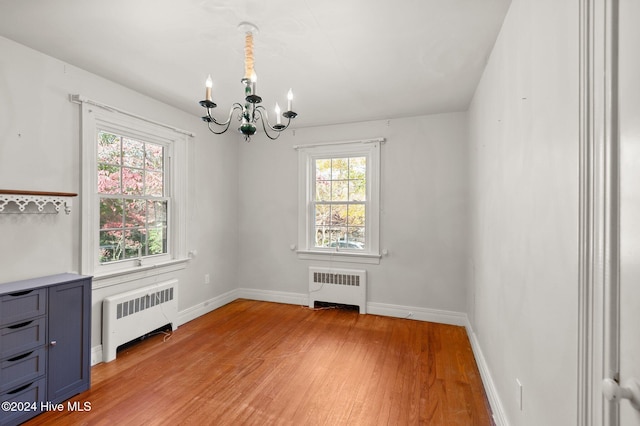 unfurnished dining area featuring radiator, a healthy amount of sunlight, and light wood-type flooring