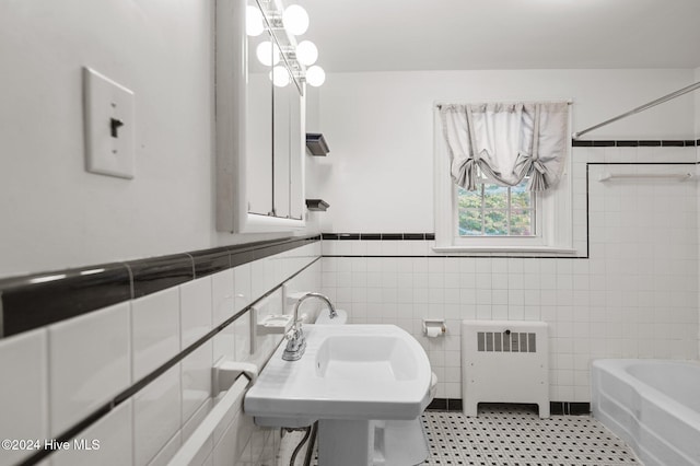 bathroom featuring radiator heating unit, tile walls, and sink