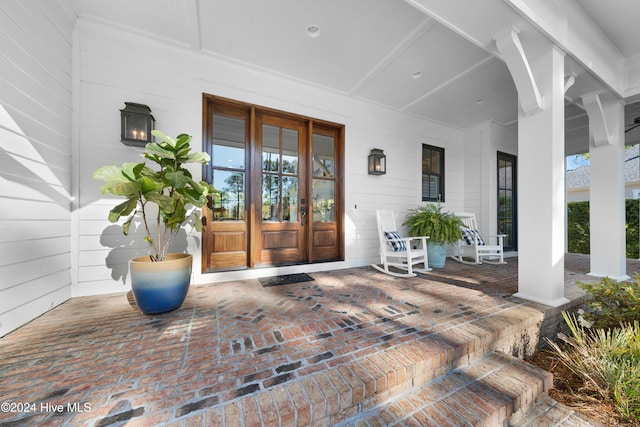 entrance to property with covered porch and french doors