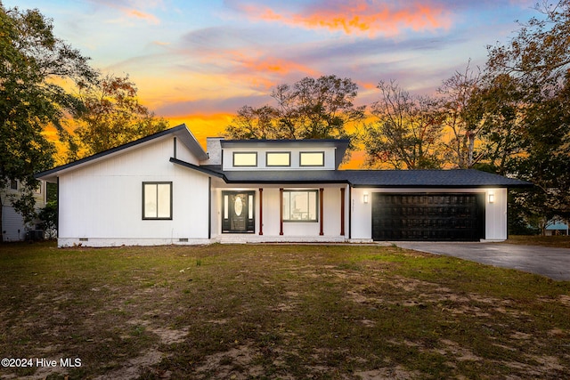 view of front of house with a lawn, covered porch, and a garage