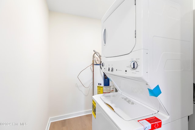 laundry room featuring light hardwood / wood-style floors and stacked washer and dryer