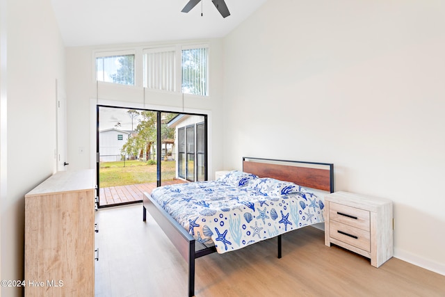 bedroom featuring access to exterior, high vaulted ceiling, light hardwood / wood-style flooring, and ceiling fan