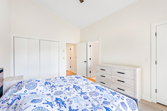 bedroom featuring ceiling fan, a closet, high vaulted ceiling, and light hardwood / wood-style floors