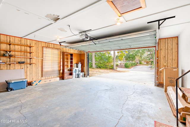 garage with a garage door opener and wooden walls