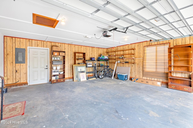 garage featuring electric panel, a garage door opener, and wooden walls