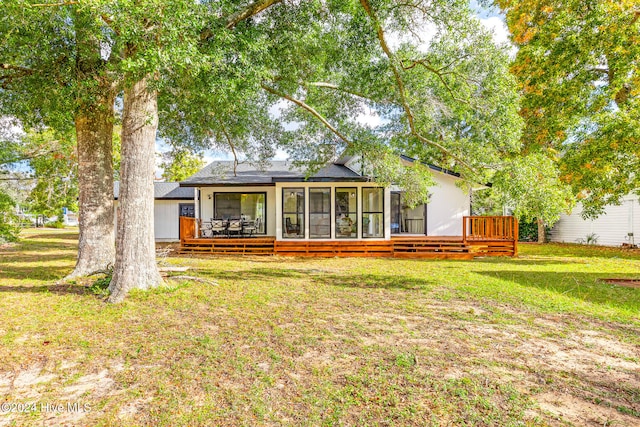 rear view of house featuring a lawn