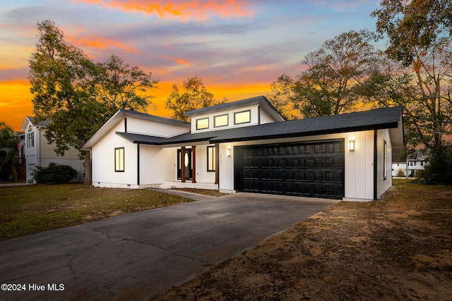 view of front of house featuring a lawn, a garage, and covered porch