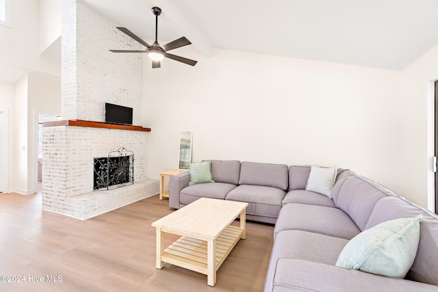 living room featuring beamed ceiling, wood-type flooring, high vaulted ceiling, and a brick fireplace