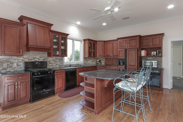 kitchen featuring black appliances, a center island, light hardwood / wood-style floors, and ornamental molding