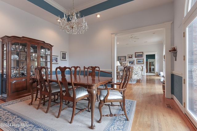 dining area with ornamental molding, ceiling fan with notable chandelier, and hardwood / wood-style flooring