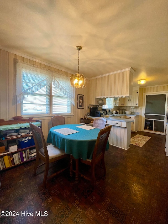 dining space with a chandelier, dark hardwood / wood-style flooring, and crown molding