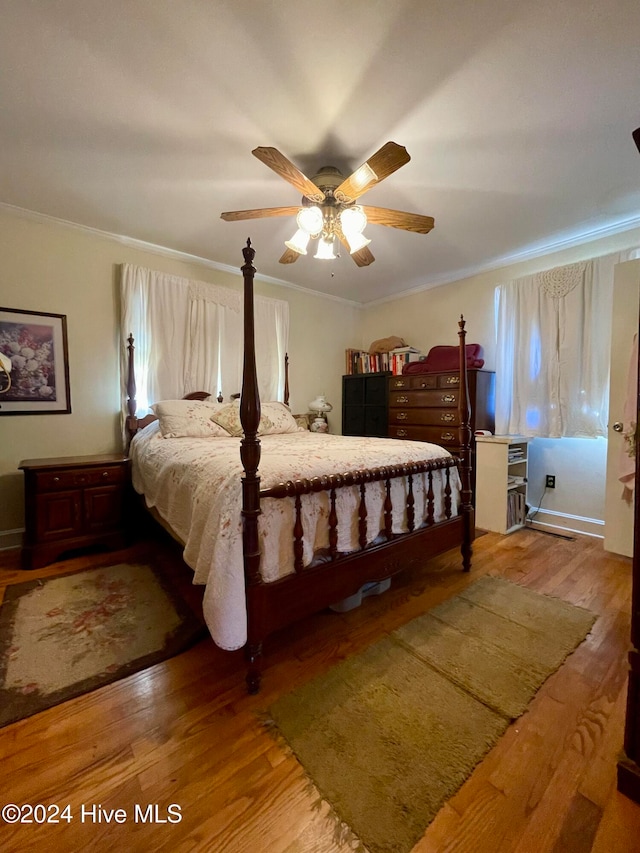 bedroom with ceiling fan, hardwood / wood-style floors, and crown molding