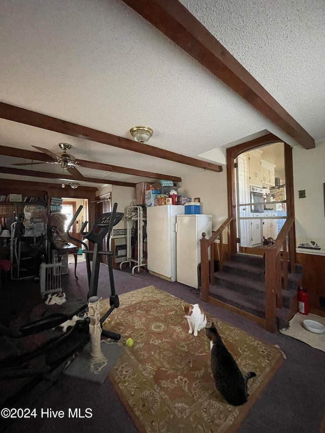 workout area with ceiling fan and a textured ceiling