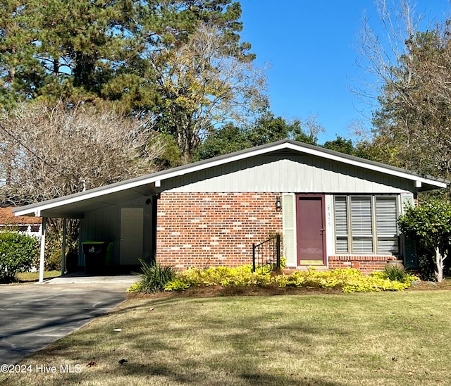 view of side of home with a lawn and a carport