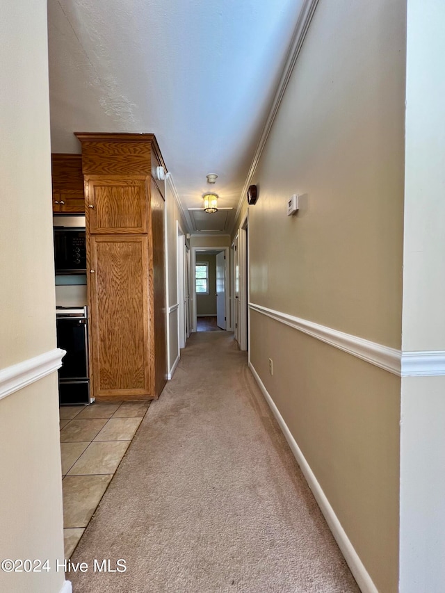 hall featuring light colored carpet and crown molding