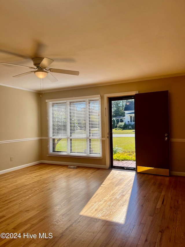 empty room featuring ceiling fan, light hardwood / wood-style floors, and ornamental molding