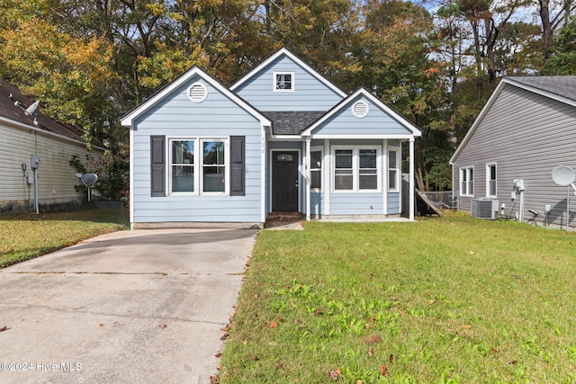 view of front of property featuring a front yard and cooling unit