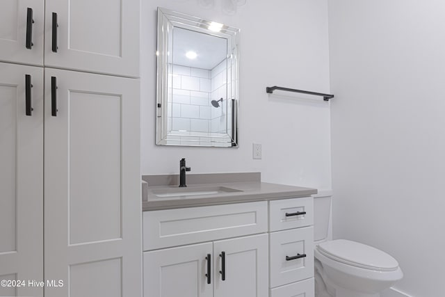 bathroom with vanity, toilet, and a shower