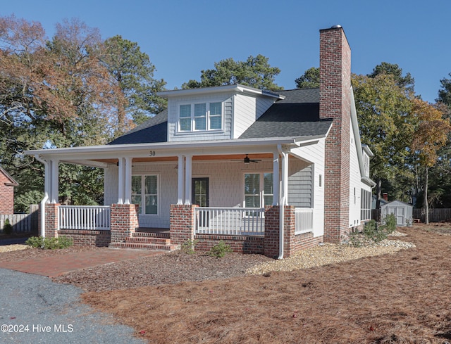 view of front of property featuring covered porch and a storage shed